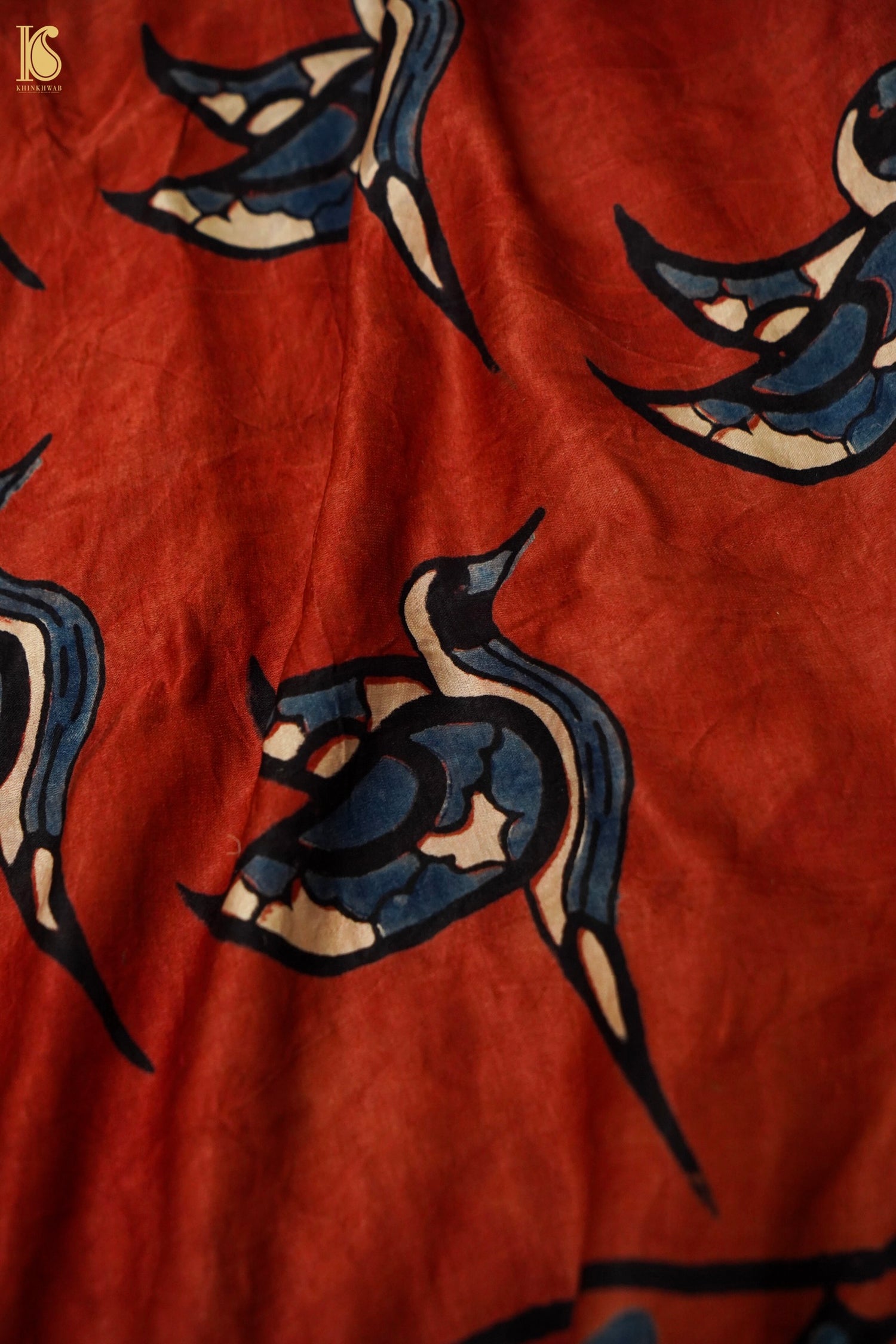 Textile with blue and black bird pattern on a red background