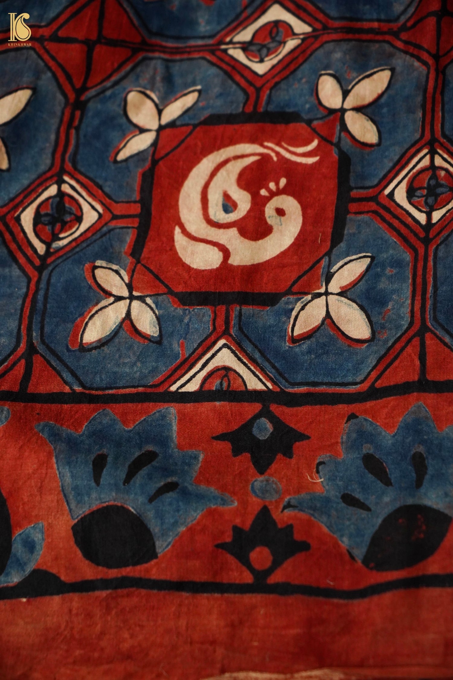 Close-up of a patterned fabric with geometric design and central emblem.