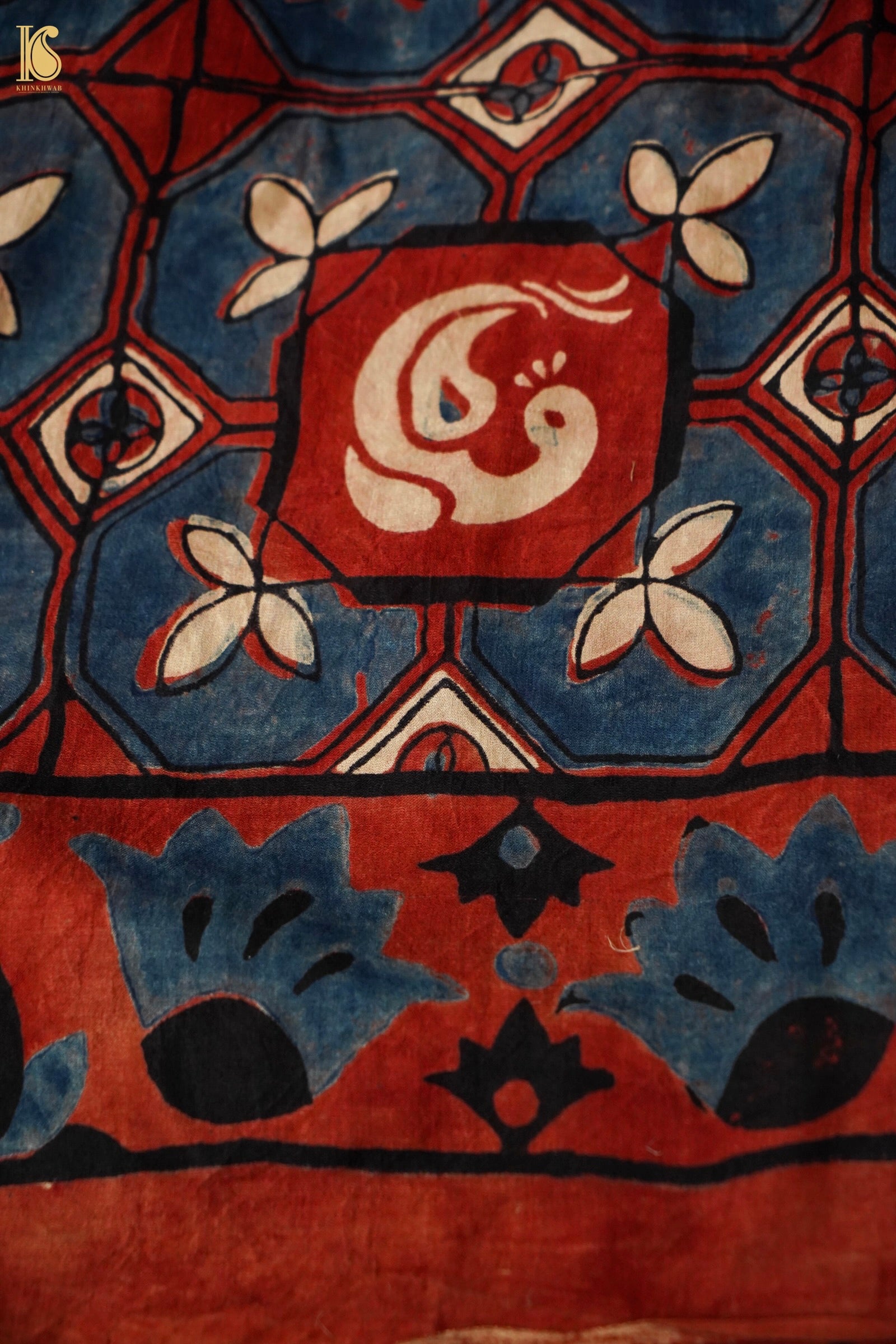 Close-up of a patterned fabric with geometric design and central emblem.